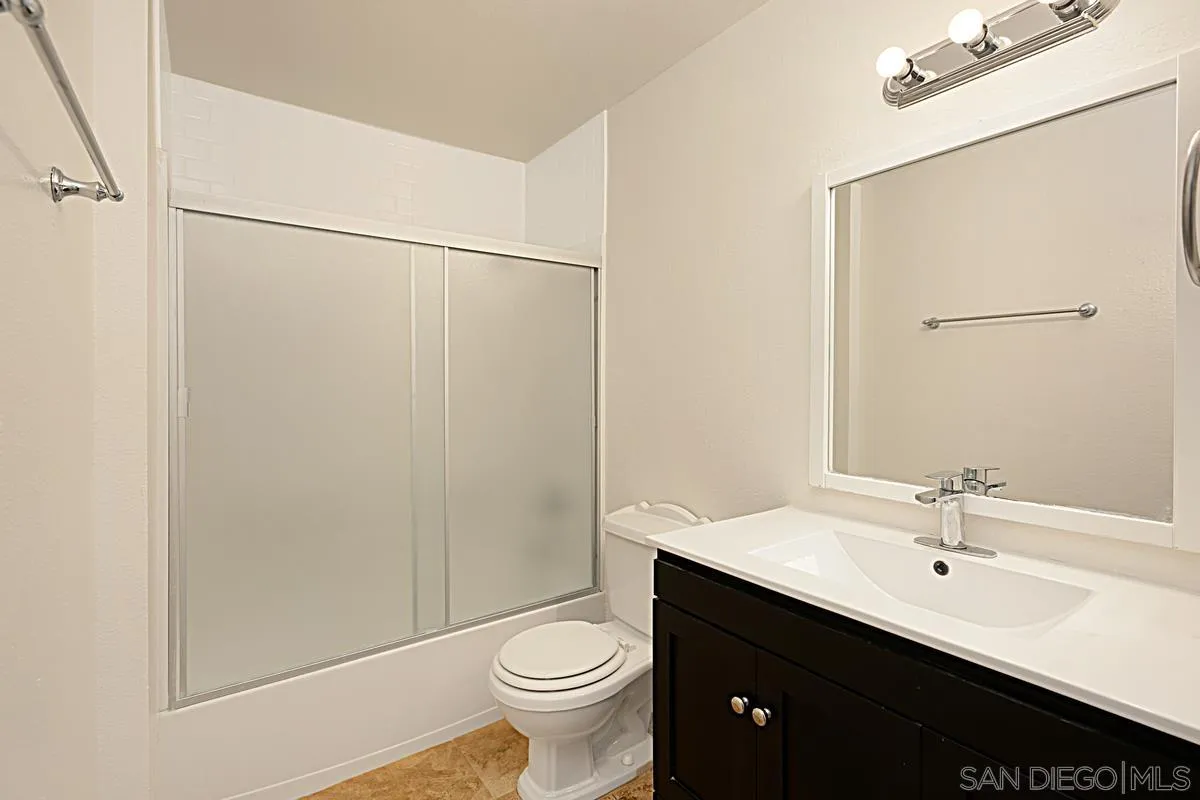 5906 Rancho Mission Road, Unit 5 San Diego, CA 92108 - Photo 18 of 33 a bathroom with a double vanity sink toilet and a mirror