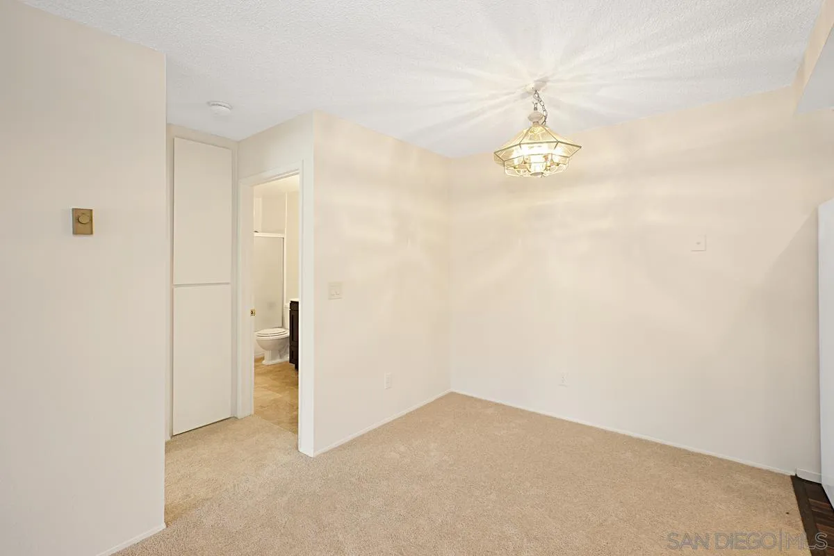 5906 Rancho Mission Road, Unit 5 San Diego, CA 92108 - Photo 9 of 33 a view of a room with wooden floor and a ceiling fan