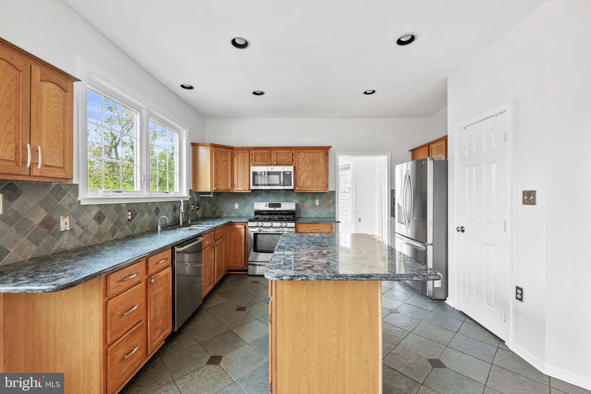 409 Midsummer Drive Gaithersburg, MD 20878 - Photo 10 of 41 a large kitchen with stainless steel appliances granite countertop a sink and cabinets
