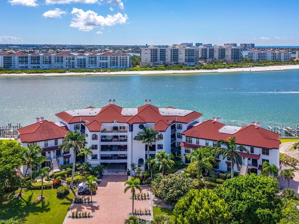 421 La Peninsula Boulevard, Unit 421 Naples, FL 34113 - Photo 13 of 18 a view of a lake with a cars parked in front of it