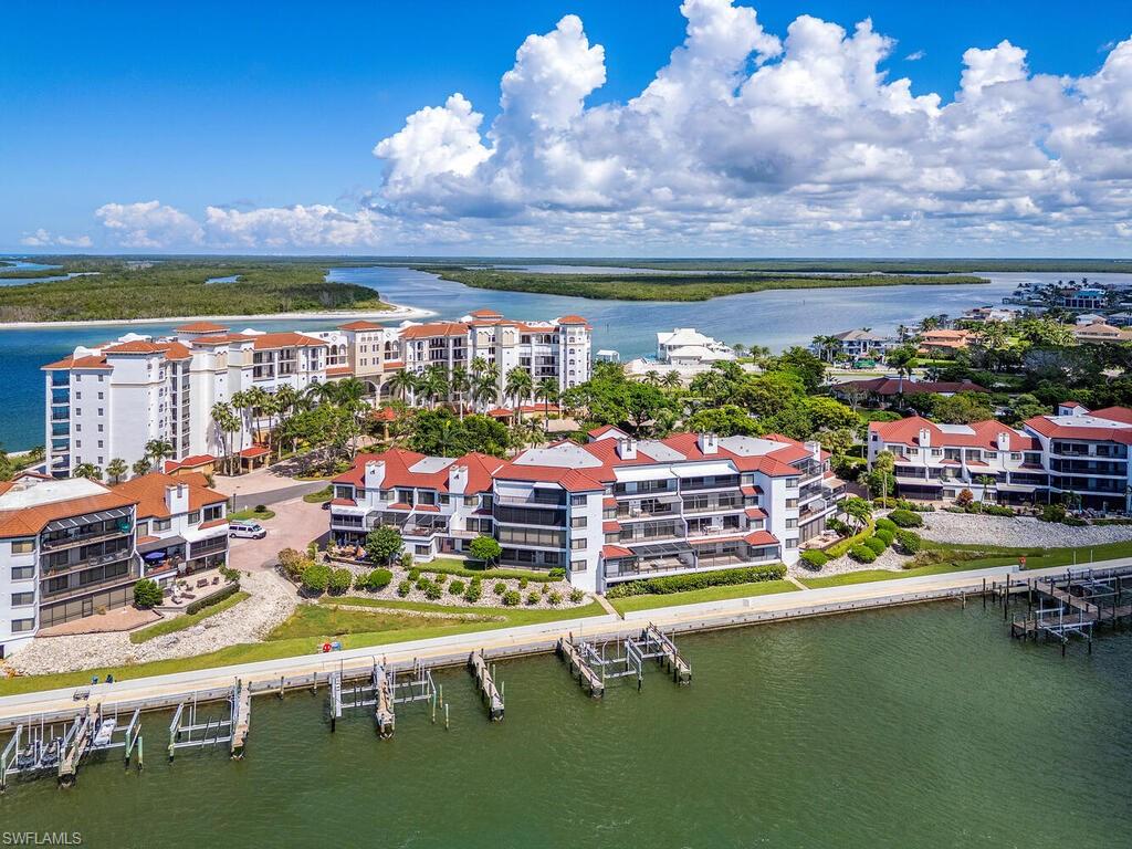 421 La Peninsula Boulevard, Unit 421 Naples, FL 34113 - Photo 15 of 18 a view of a lake with a table and chairs