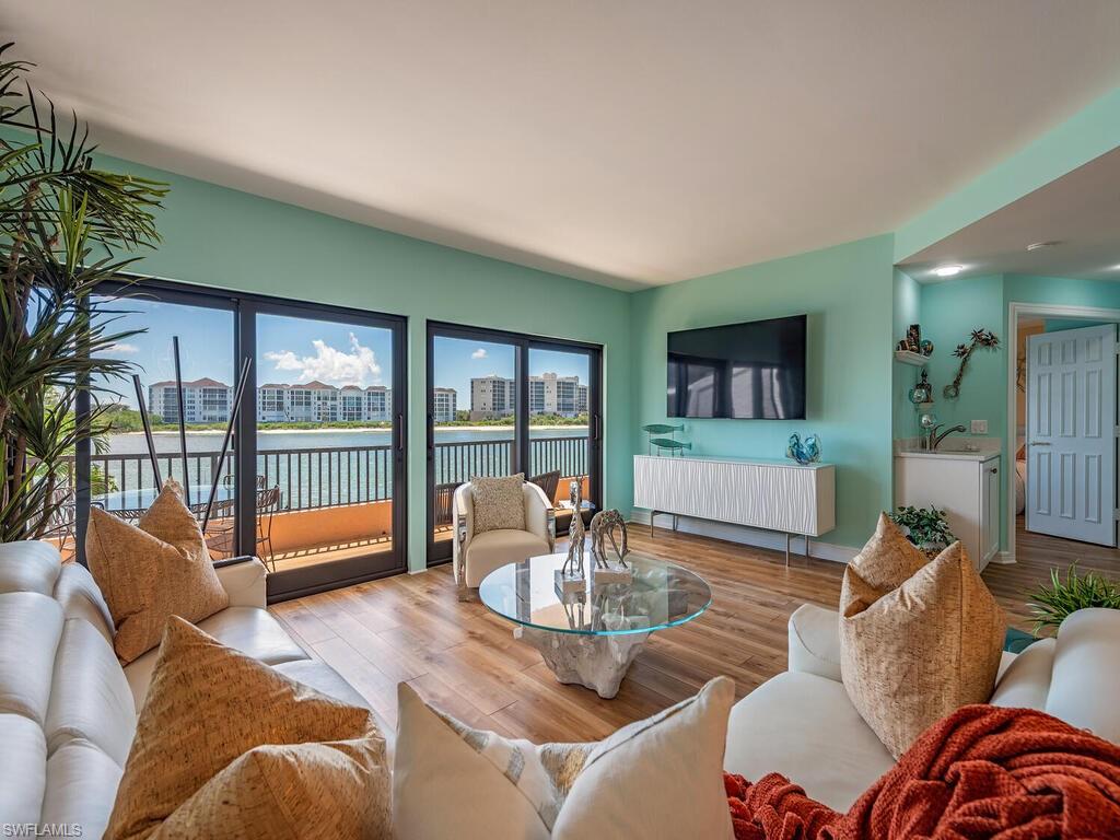 421 La Peninsula Boulevard, Unit 421 Naples, FL 34113 - Photo 3 of 18 a living room with furniture and a large window with balcony view