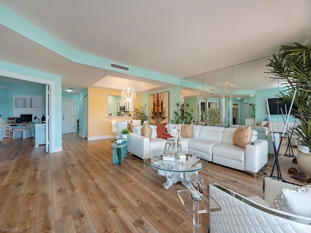 421 La Peninsula Boulevard, Unit 421 Naples, FL 34113 - Photo 4 of 18 a living room with furniture and wooden floor