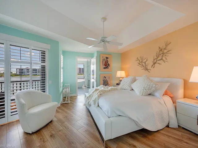 a bedroom with a bed couch and a large window
