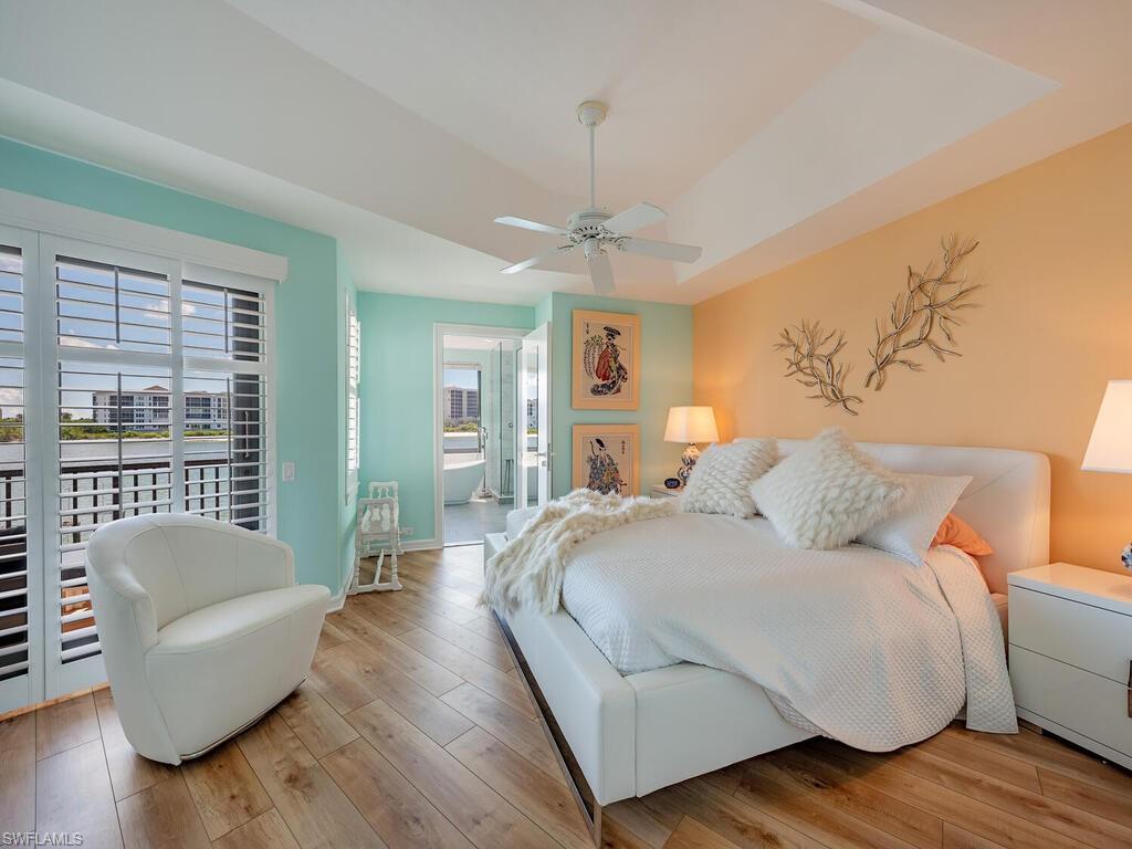 421 La Peninsula Boulevard, Unit 421 Naples, FL 34113 - Photo 7 of 18 a bedroom with a bed couch and a large window