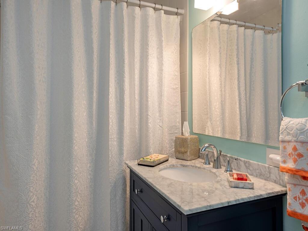 421 La Peninsula Boulevard, Unit 421 Naples, FL 34113 - Photo 10 of 18 a bathroom with a sink and a mirror