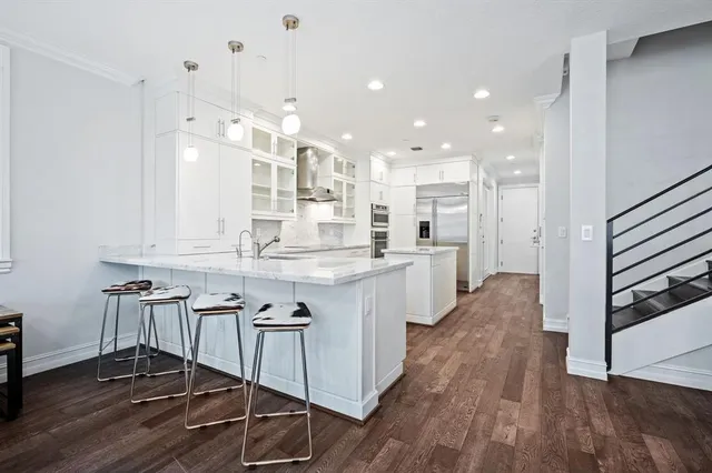 a kitchen with kitchen island granite countertop a sink cabinets and wooden floor