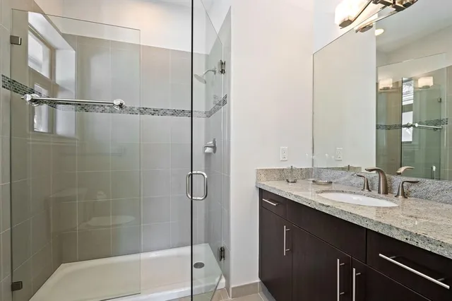 a bathroom with a granite countertop sink mirror bathtub and shower