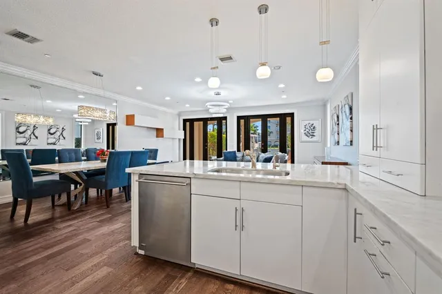 a kitchen with stainless steel appliances kitchen island granite countertop a stove a sink a dining table and chairs