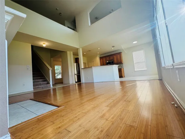 a view of a living room with kitchen view and wooden floor