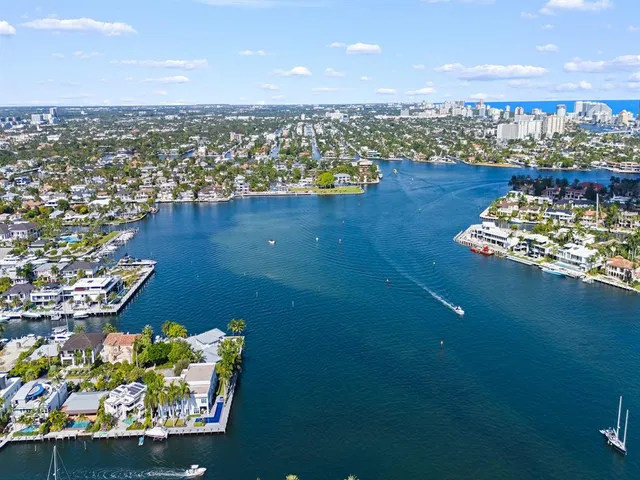 an aerial view of a city with lots of residential buildings ocean and mountain view in back