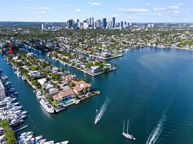 an aerial view of a city with lots of residential buildings ocean and mountain view in back