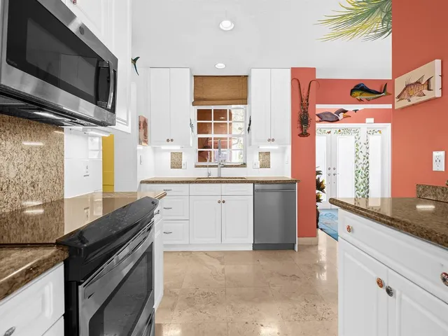 a kitchen with stainless steel appliances a sink stove and cabinets