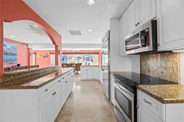 a kitchen with stainless steel appliances granite countertop a sink and a stove