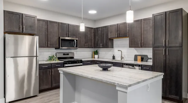 a kitchen with wooden cabinets and stainless steel appliances