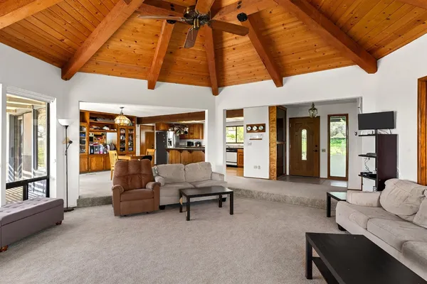 a kitchen with stainless steel appliances granite countertop a refrigerator a sink dishwasher a stove and white countertops with wooden floor