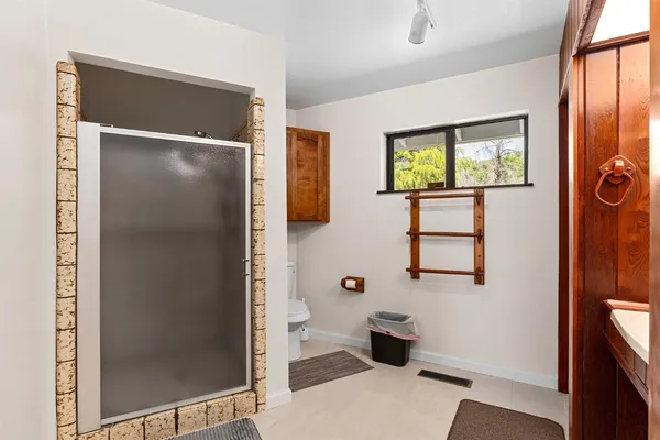 a bathroom with a granite countertop sink a mirror and a toilet