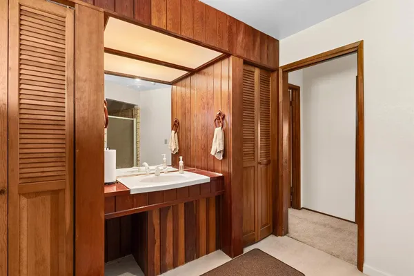 a bathroom with double vanity sinks a mirror and a shower