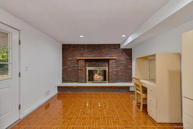 a view of empty room with a fireplace and window