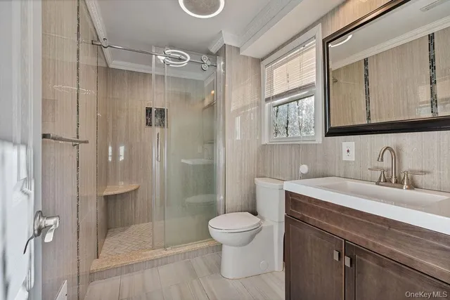 a bathroom with a granite countertop sink a toilet and shower