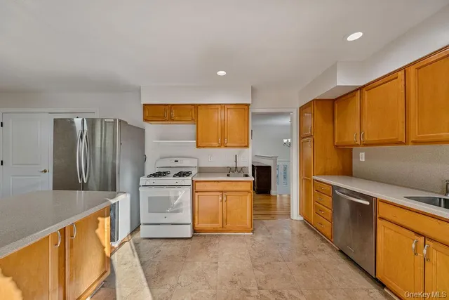 a kitchen with stainless steel appliances granite countertop a stove a sink and a refrigerator