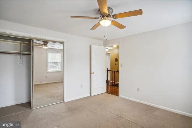 an empty room with a ceiling fan and shower