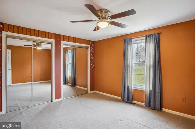 an empty room with window and a ceiling fan