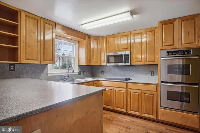 a kitchen with stainless steel appliances granite countertop a sink stove and microwave