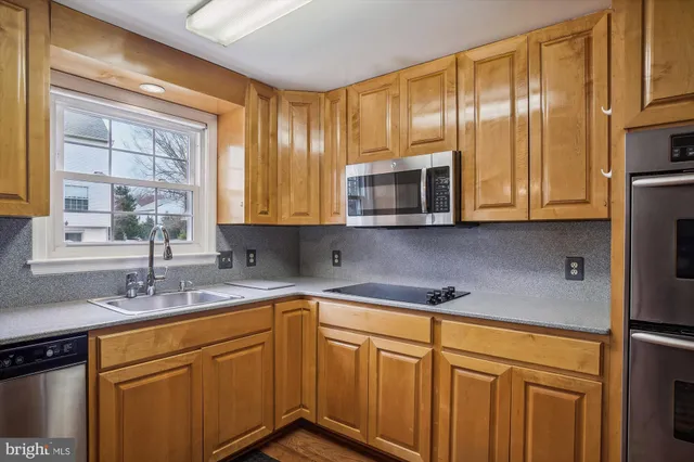 a kitchen with stainless steel appliances granite countertop a sink a stove and cabinets