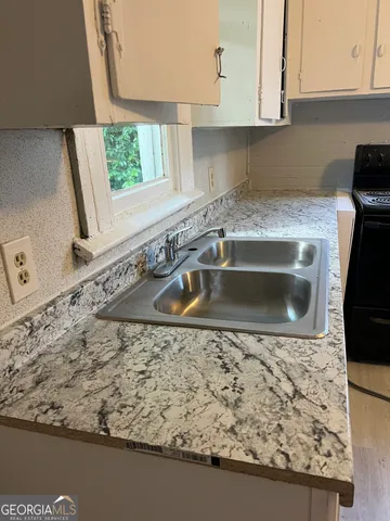 a kitchen with a sink a stove and a window