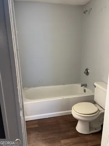 a bathroom with a toilet and a bath tub