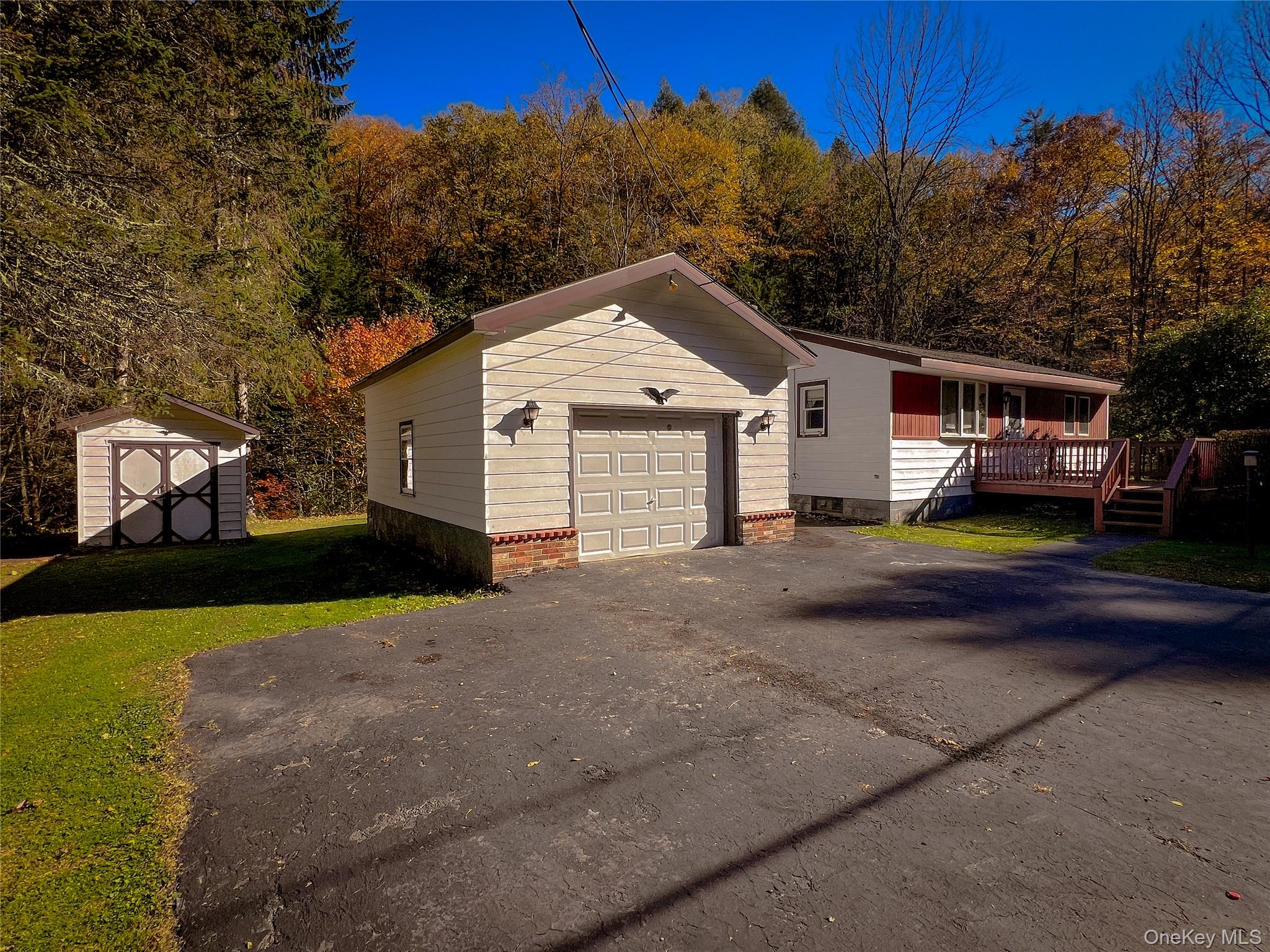 259 Tennanah Lake Road Roscoe, NY 12776 - Photo 11 of 11 View of front of home with a wooden deck, a storage shed, asphalt driveway, and a front yard