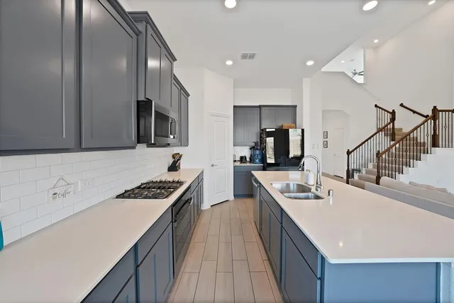 a kitchen with a sink a stove and cabinets