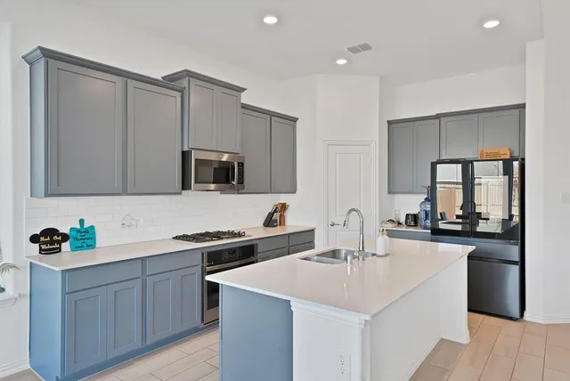 a kitchen with sink a microwave and cabinets