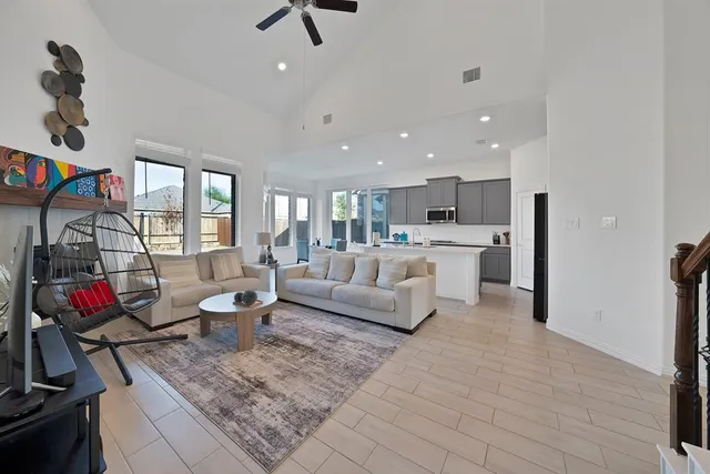 a living room with stainless steel appliances furniture and a rug