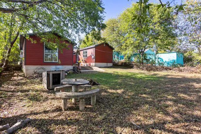 a backyard of a house with table and chairs