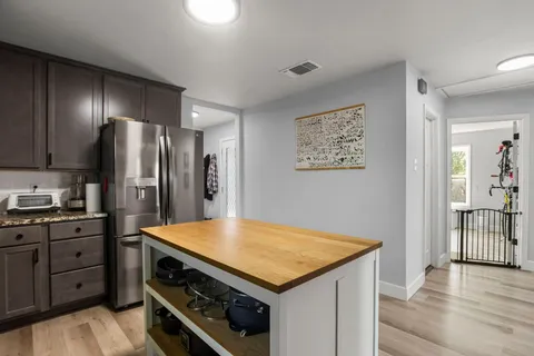 a kitchen with a stove a refrigerator and a stove top oven