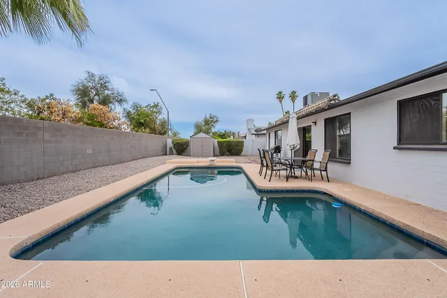 a view of a swimming pool with a patio and a yard
