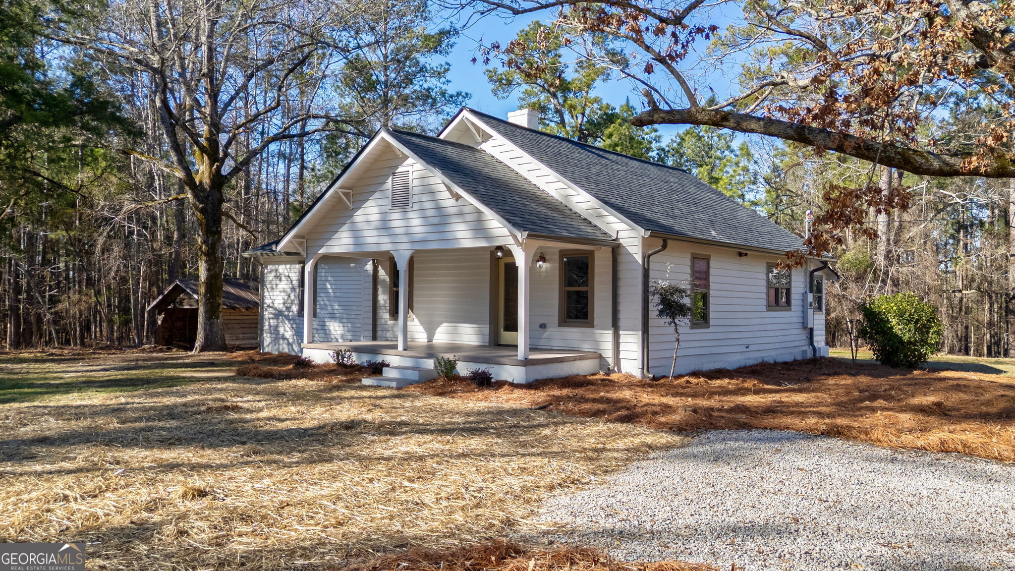 a view of a house with a yard and large tree