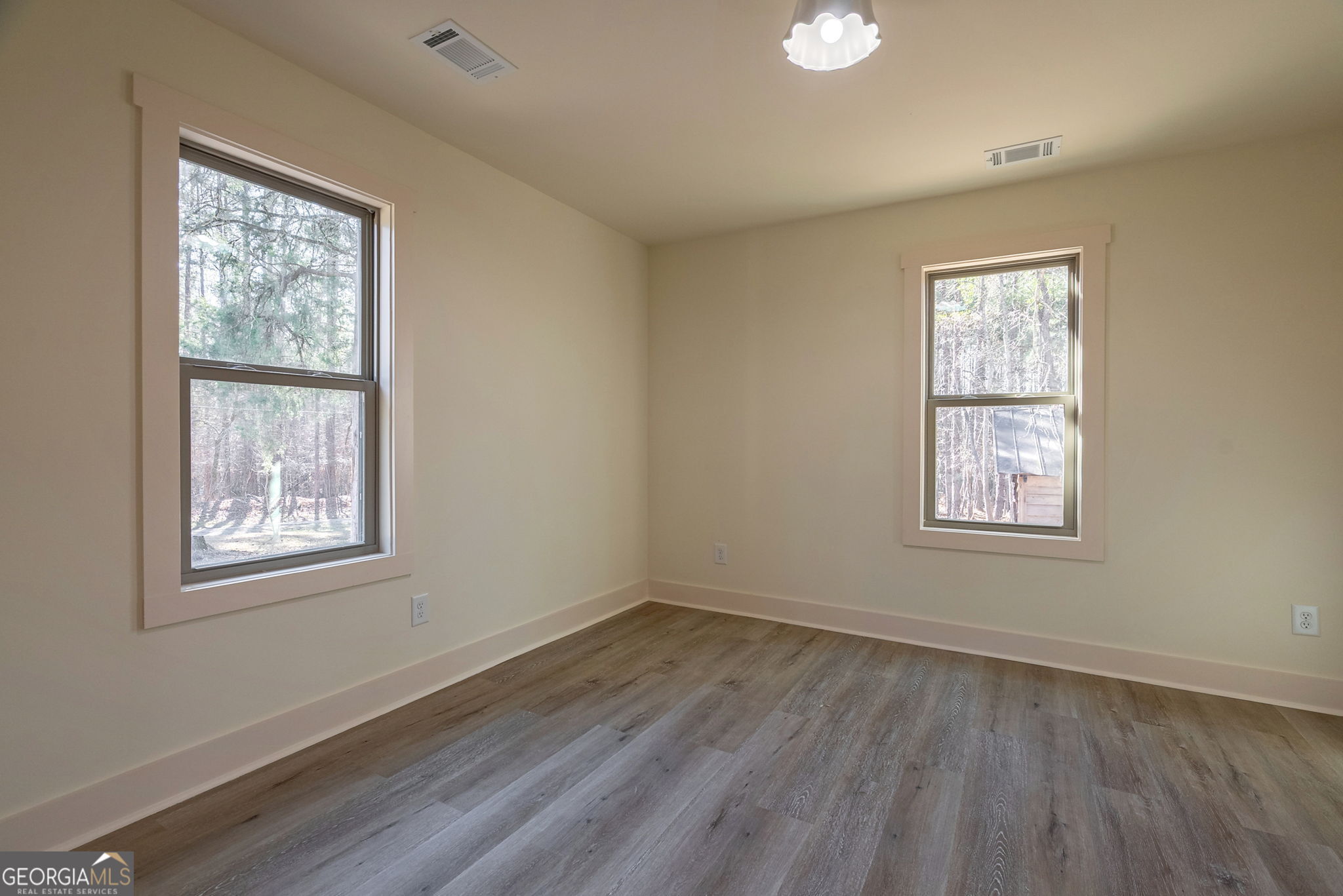 1021 Twins Road Greensboro, GA 30642 - Photo 13 of 32 a view of an empty room with wooden floor and a window