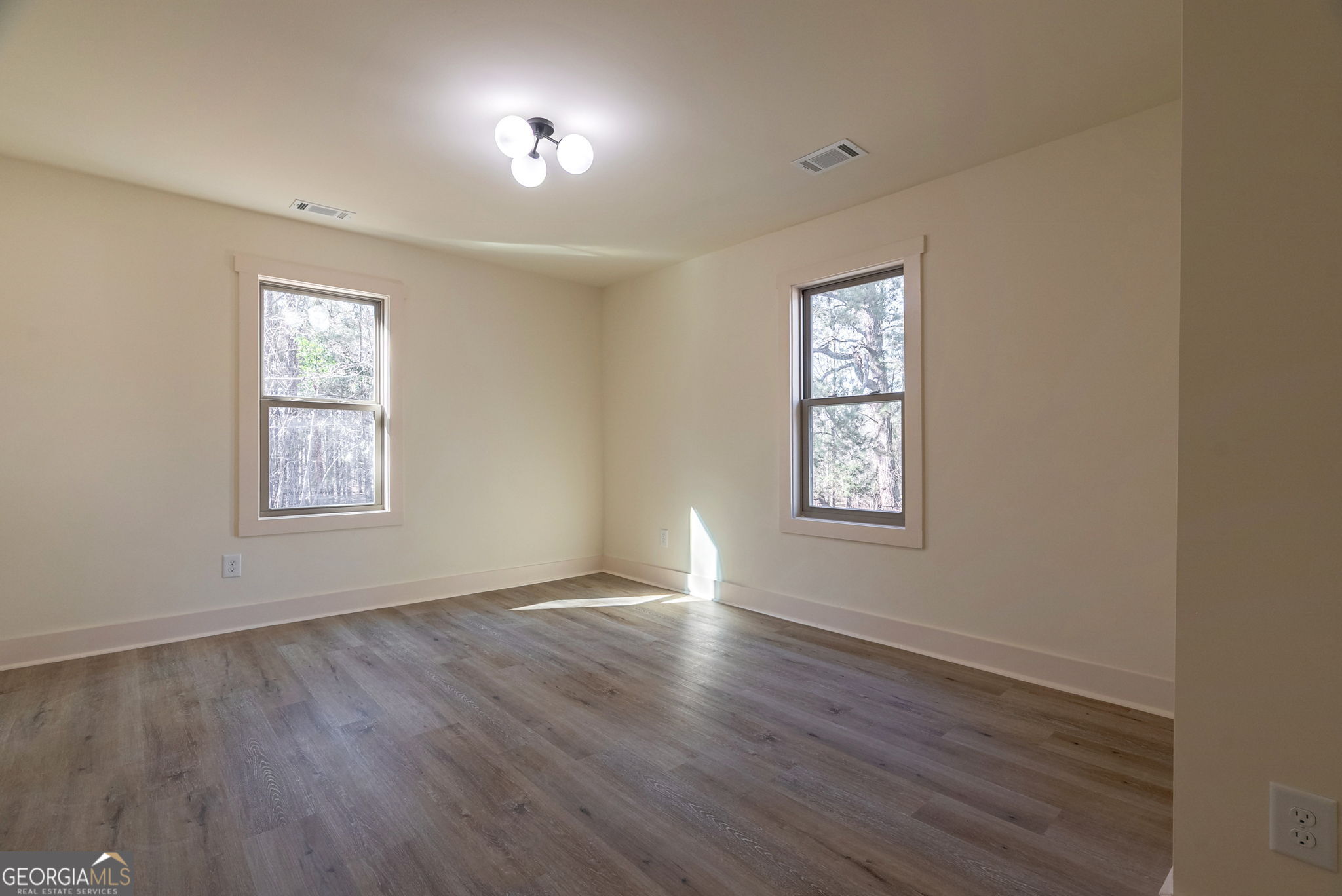 1021 Twins Road Greensboro, GA 30642 - Photo 16 of 32 a view of an empty room with wooden floor and a window