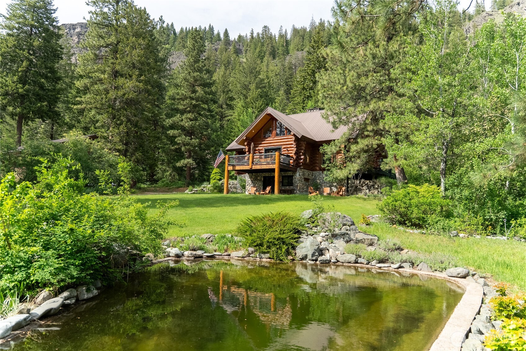 116 Lost River Road Mazama, WA 98833 - Photo 2 of 40 a aerial view of a house with swimming pool and green valley