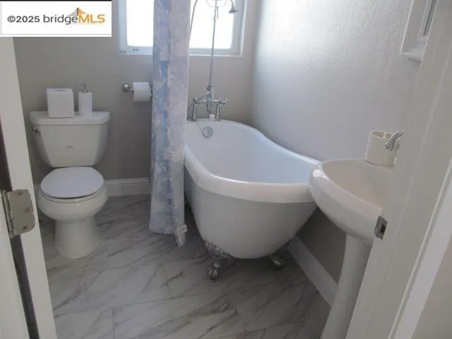 a white toilet sitting next to a white sink