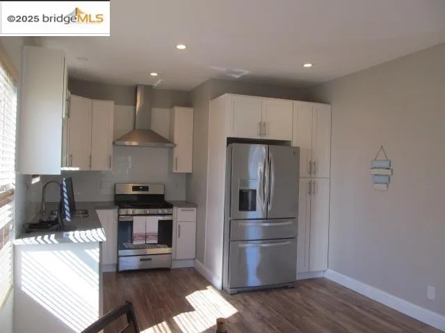 a kitchen with stainless steel appliances a refrigerator and a stove top oven