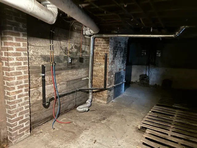 a room with water heater and a wooden door