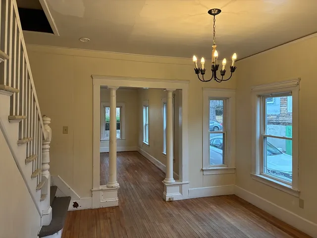 a view of a livingroom with wooden floor and stairs