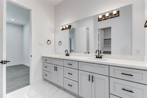 a bathroom with a double vanity sink and a mirror