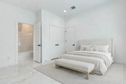 a spacious bedroom with a bed and a shower