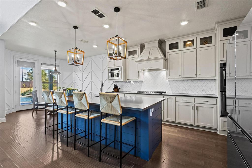 13798 Fernando Road Frisco, TX 75035 - Photo 12 of 39 an open kitchen with granite countertop a stove a sink a dining table and chairs with wooden floor