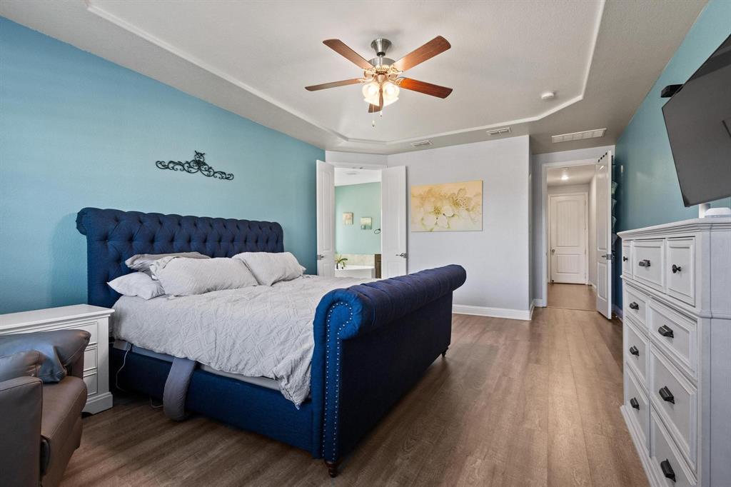 13798 Fernando Road Frisco, TX 75035 - Photo 18 of 39 a bedroom with a bed and a flat tv screen on dresser